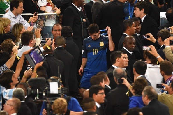 Messi se saca la medalla ante los flashes del público. Leo no tuvo un buen partido en la final ante Alemania, en julio de 2014.