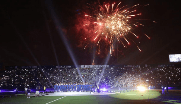 La gente saca sus celulares, mientras los fuegos artificiales explotan sobre el Matute