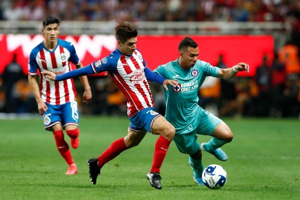 Brizuela disputa un balón y Antuna observa de fondo.