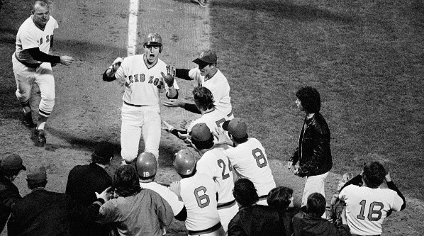 Red Sox catcher Carlton Fisk is greeted by his teammates at home plate after hitting the scoring run in game 6 of the 1975 World Series against the Cincinnati Reds. (Getty)