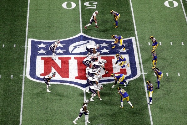 A equipe do New England Patriots (de branco, esq.) com a posse de bola prestes a realizar mais uma descida contra a defesa do Los Angeles Rams (de azul, a dir.) no Super Bowl 53 (Getty images)