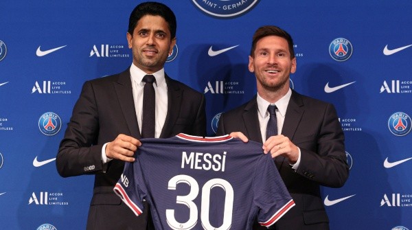 Lionel Messi poses with his jersey next to President Nasser Al Khelaifi / Sebastien Muylaert/Getty Images