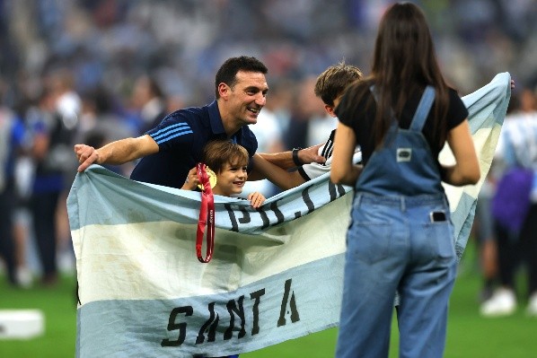 Lionel Scaloni, junto a sus hijos, con una bandera de Pujato en los festejos del Mundial de Qatar 2022 (Foto: Getty Images)