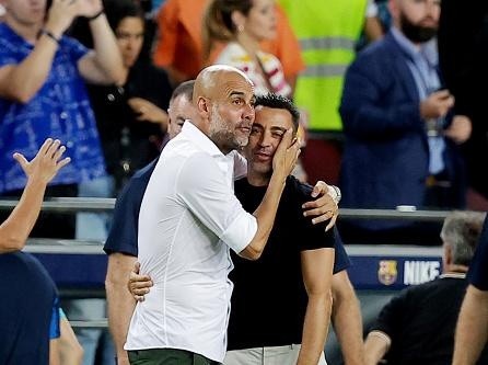 Manchester City/Manchester City FC via Getty Images - Guardiola abraçando Xavi, ambos trabalharam juntos no Barcelona