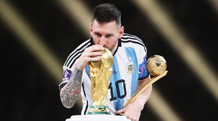 LUSAIL CITY, QATAR - DECEMBER 18: Lionel Messi of Argentina kisses the FIFA World Cup Qatar 2022 Winners' Trophy while holding the adidas Golden Boot award after the FIFA World Cup Qatar 2022 Final match between Argentina and France at Lusail Stadium on December 18, 2022 in Lusail City, Qatar. (Photo by Julian Finney/Getty Images)